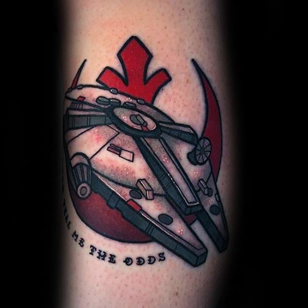 Millennium Falcon tattoo with red Rebel Alliance symbol and bold black text below that reads “me the odds” in a curved layout.