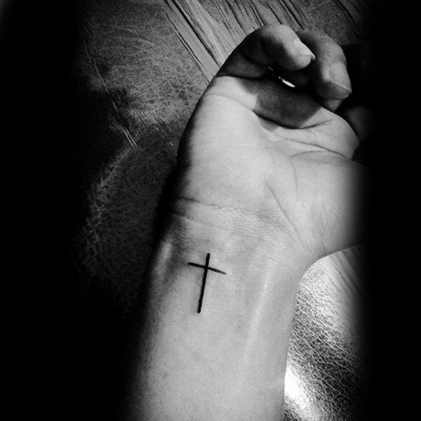 Black cross tattoo on the inner wrist