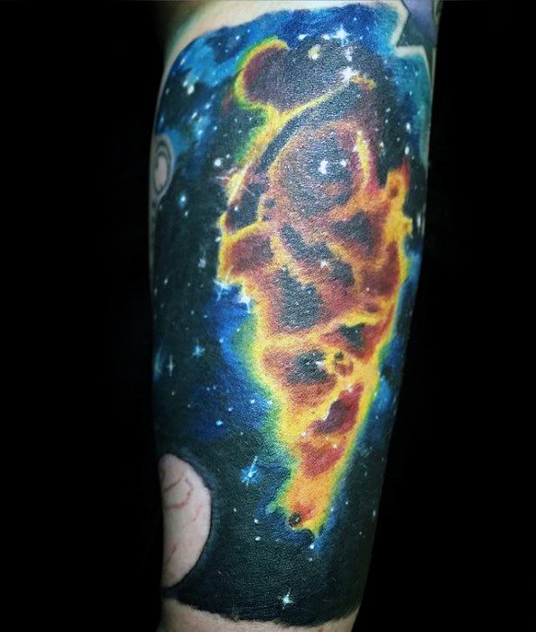 Vibrant nebula tattoo with colorful stars and planets gracing a forearm