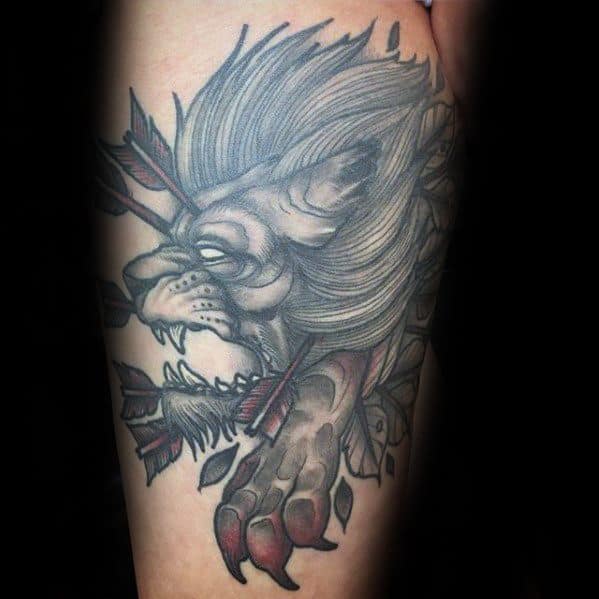 Neo-traditional lion tattoo with a dramatic grayscale mane, arrows through the head, and bold red claw details for an intense look.