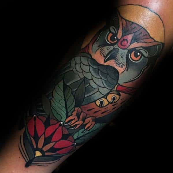 Neo-traditional owl tattoo with bold colors, intense eyes, floral accents, and intricate shading, creating a striking and detailed design.