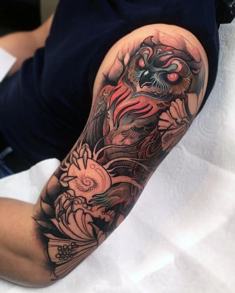Neo-traditional owl tattoo sleeve with bold shading, fiery details, and floral elements, creating a dramatic and intricate design.