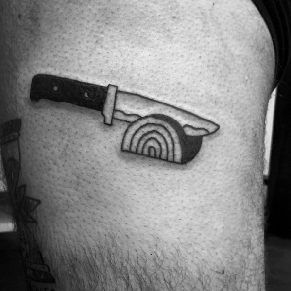Minimalist black ink tattoo of a knife slicing through a halved onion, featuring bold lines and simple shading for a clean, modern look.