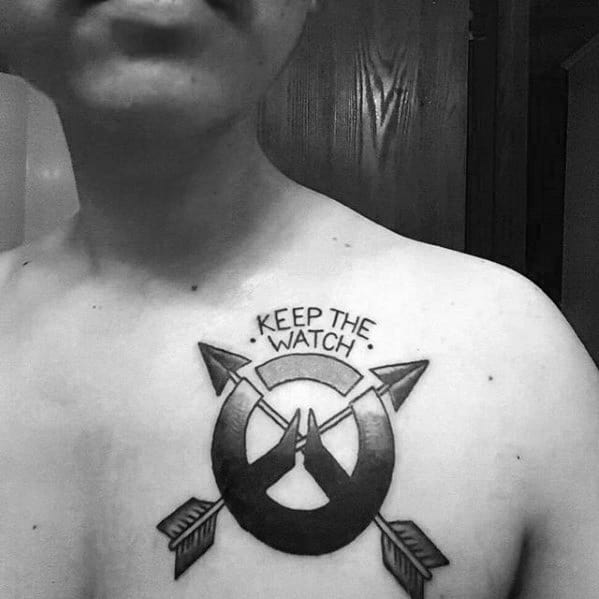 Blackwork tattoo of the Overwatch logo with crossed arrows and the phrase "Keep the Watch" inked on the upper chest.