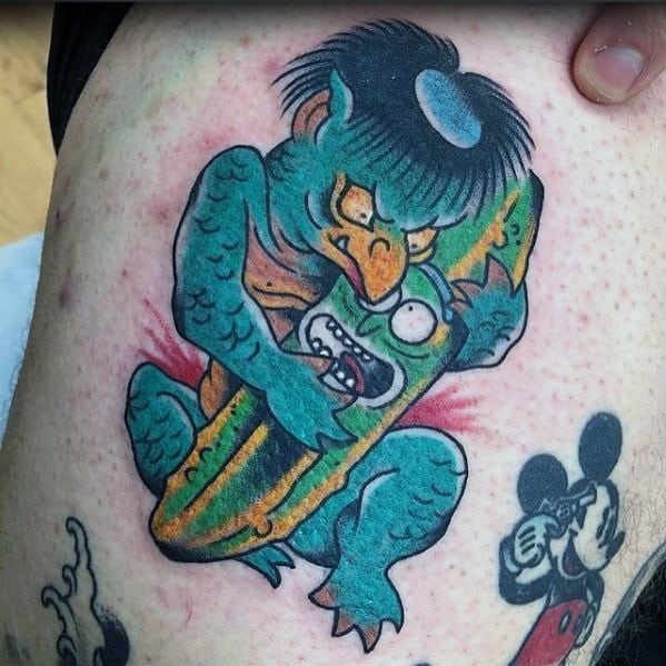 Pickle Rick tattoo with a Japanese-inspired monster gripping him, featuring bold colors, dynamic shading, and a unique artistic twist.