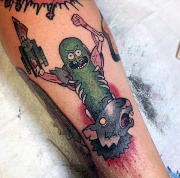 Pickle Rick tattoo in cyborg form, holding a weapon and wearing a rat's head, featuring bold lines and intense shading on the leg.