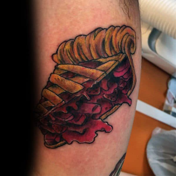 Cherry pie slice tattoo with a lattice crust and dripping filling, blending traditional tattoo style with a bold and slightly edgy design