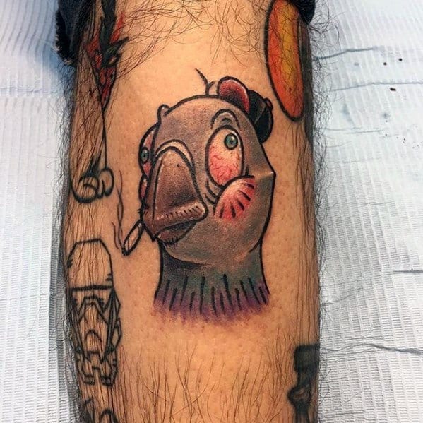 Colorful cartoon pigeon tattoo with blushed cheeks, wearing a cap and smoking, adding humor and attitude to the quirky design.