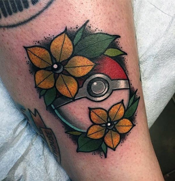 Traditional-style Pokeball tattoo surrounded by bold yellow flowers and green leaves with black shading and dotwork accents.