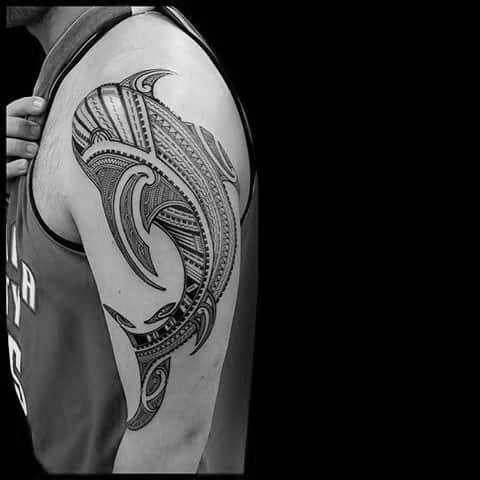Polynesian shark tattoo on upper arm with intricate tribal patterns representing protection, strength, and deep cultural roots.