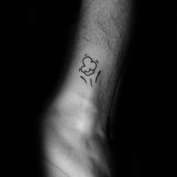 Minimalist tattoo of a single popcorn kernel with motion lines, placed on the inner wrist in a simple black ink style.