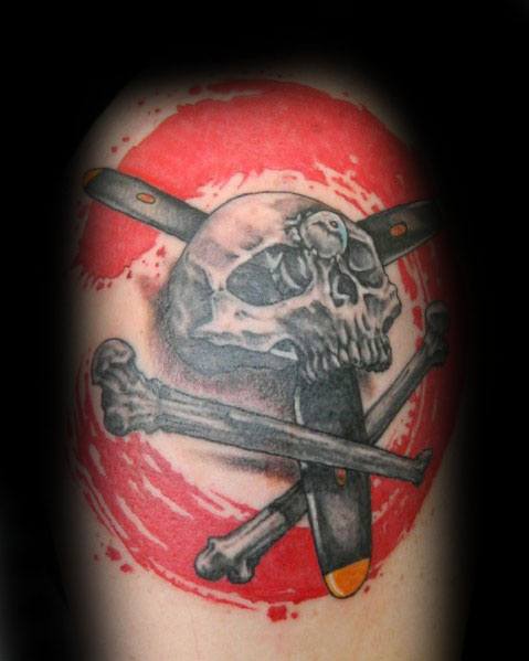 Bold upper arm tattoo featuring a skull and crossbones with a propeller replacing one bone, set against a striking red circular background.