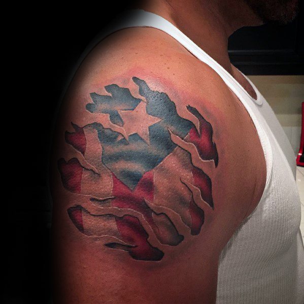Puerto Rican flag tattoo on the shoulder with a torn skin effect, revealing bold red, white, and blue colors with a striking star design.