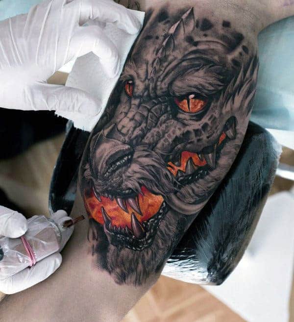 Dragon tattoo with fierce orange eyes and sharp teeth