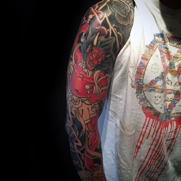 Bold Raijin half sleeve tattoo with vivid red tones, thunder drum details, and fierce deity design in traditional Japanese style.