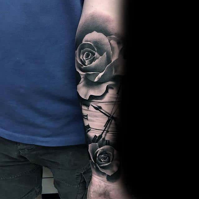 Realistic black and grey rose tattoo with a clock motif on the forearm, featuring detailed shading and intricate design