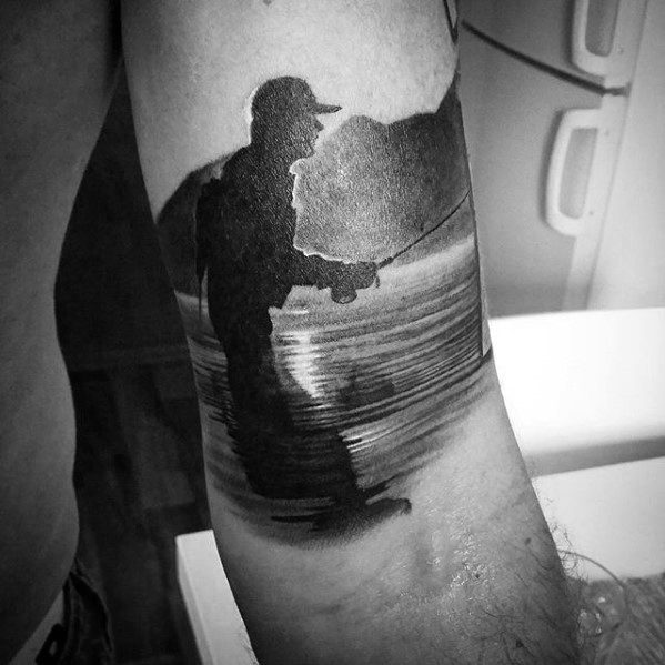 Black and grey tattoo of a fisherman casting a line in calm waters, with scenic mountains and reflections creating a peaceful, nature-inspired design.