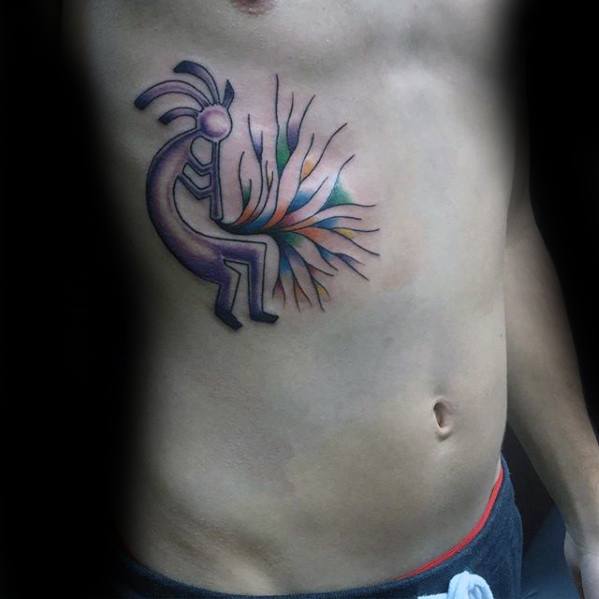 Kokopelli chest tattoo in soft purple tones with colorful burst lines, blending tribal symbolism with a dynamic abstract flair.
