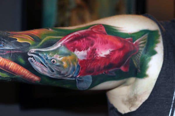 Vibrant tattoo of a red salmon swimming through lush green waters, with realistic shading and bold colors for a striking and lifelike design.