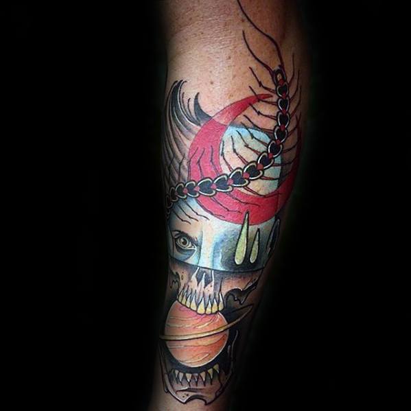 Bold Saturn tattoo design for men combining a skull, red crescent moon, and planet rings with vivid colors and surreal elements.