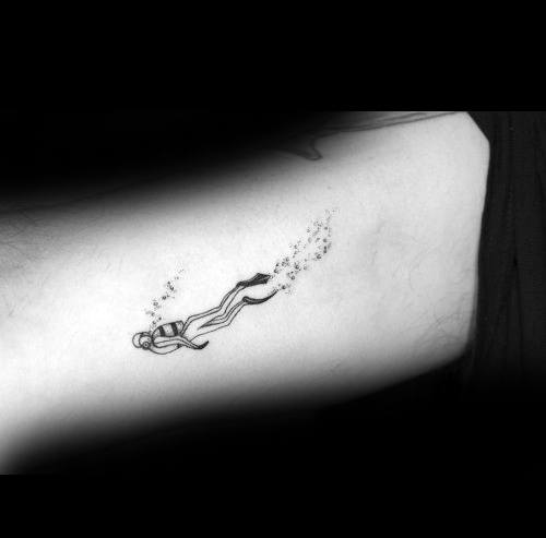 Fine line scuba diver tattoo on ribs, showing diver swimming with bubbles trailing behind in minimalist style.