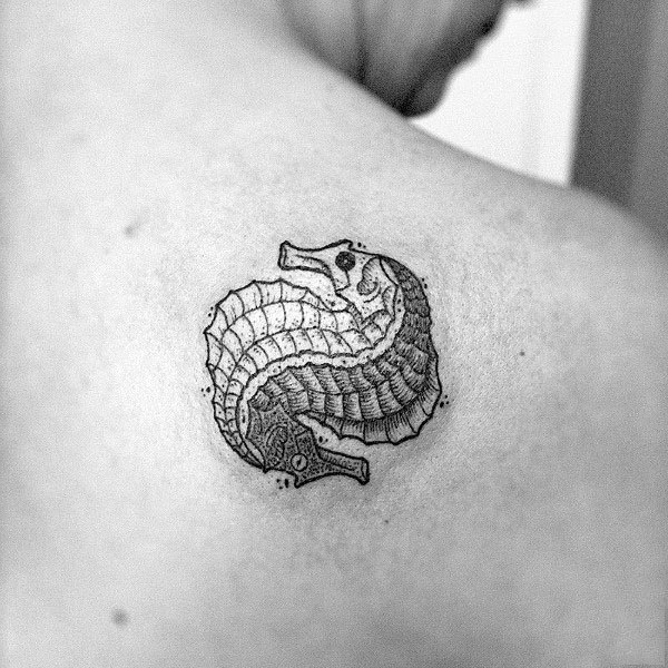 Small intricate seahorse tattoo on upper back, featuring fine linework and a curled design for a unique and detailed artistic look.
