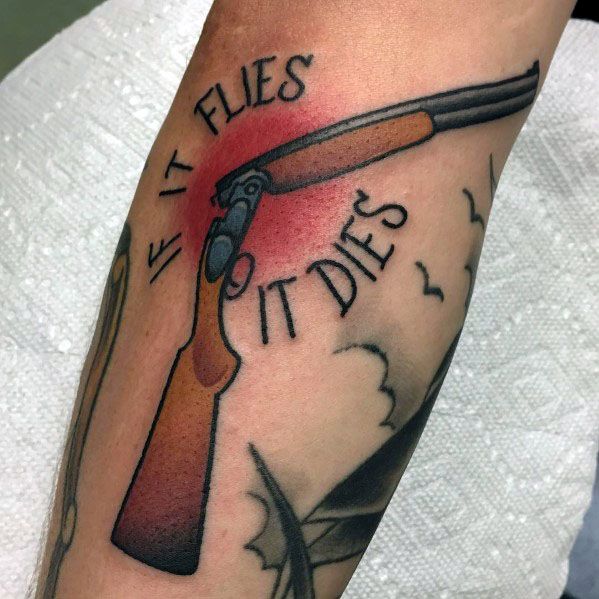Traditional shotgun tattoo with "If It Flies, It Dies" text, featuring bold black outlines, shading, and a red background for a striking design.