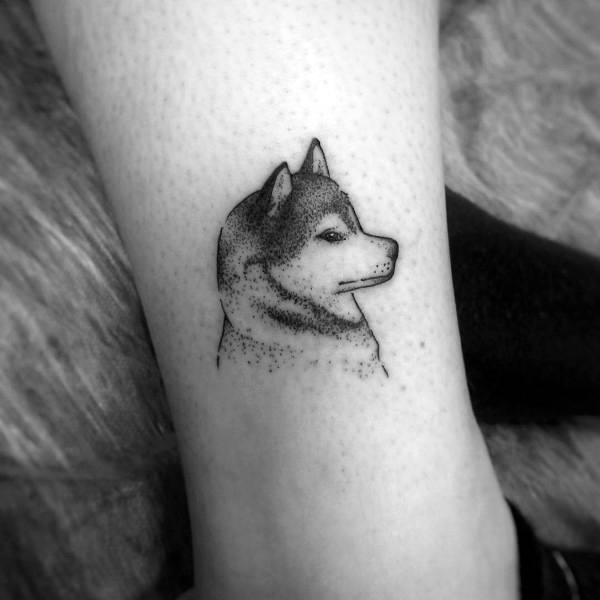 Minimalist Siberian Husky tattoo on a man's leg, featuring fine dot work and clean lines for a simple yet elegant design.