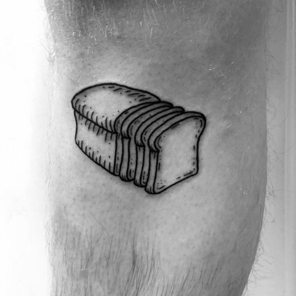 Black ink tattoo of a sliced loaf of bread with clean lines and minimal shading, creating a simple yet bold design on the skin.