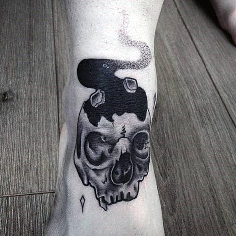 Tattoo of a burning skull with smoke rising