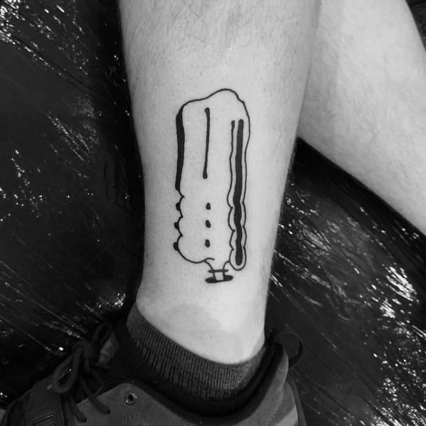 Black and white tattoo of Snoopy lying upside down, resembling a melting effect, placed on a person's lower leg.