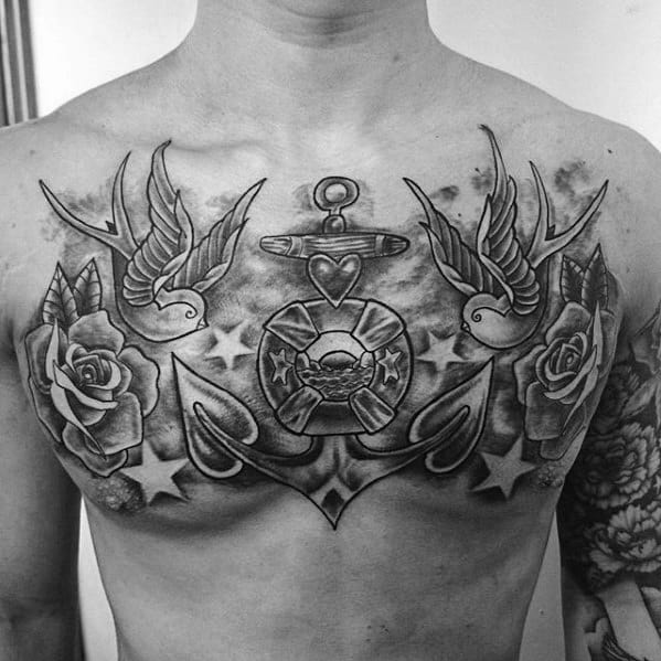 Black and white chest tattoo featuring sparrows, roses, an anchor, and stars