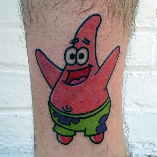 Cheerful Patrick Star tattoo on the leg, with arms raised and a big smile, wearing his classic green and purple shorts.