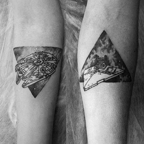 Matching forearm tattoos of the Millennium Falcon and a Star Destroyer, set against galaxy-filled triangle backgrounds.