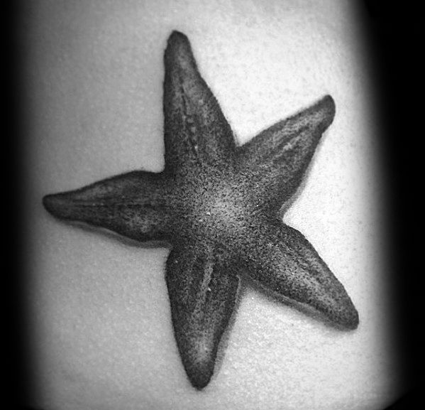 Black and grey starfish tattoo with soft shading and a textured center, creating a simple yet realistic underwater look.
