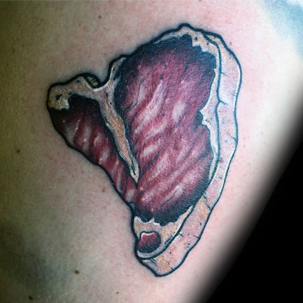Tattoo of a detailed steak with bold black outlines, rich marbling, and a seared effect, creating a realistic and textured meat-inspired design