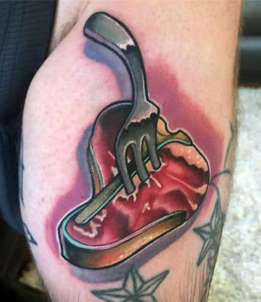 Tattoo of a heart-shaped steak pierced by a fork, with bold shading and a red glow effect, creating a striking and dynamic meat-inspired design