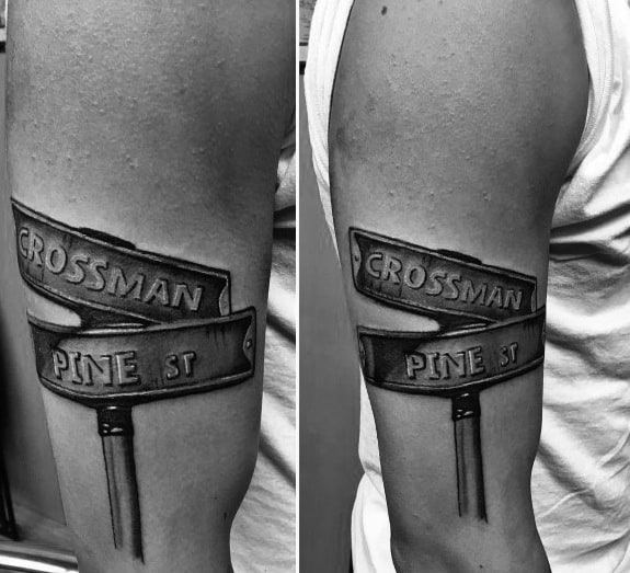 Black and grey tattoo of a street signpost featuring 'Grossman' and 'Pine St' with bold lettering and a realistic, shaded design.