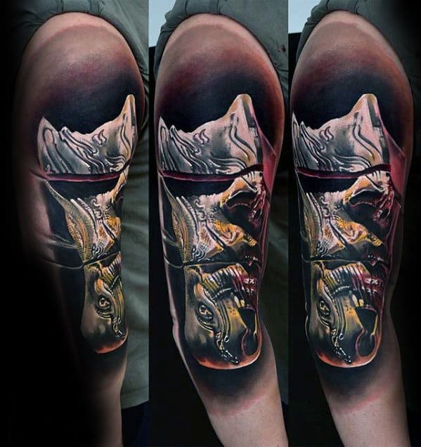 Surrealist tattoo of a face split in half with a distorted golden skull below, creating a haunting illusion of dual identity.