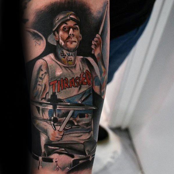 Realistic tattoo of Travis Barker playing the drums, wearing a "Thrasher" shirt, with detailed shading and vibrant colors capturing his likeness and energetic pose.