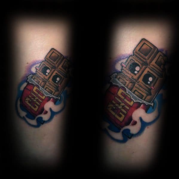 Tattoo of a cute anthropomorphic chocolate bar with big eyes, emerging from a red wrapper labeled "CHO," surrounded by a cloud-like design.