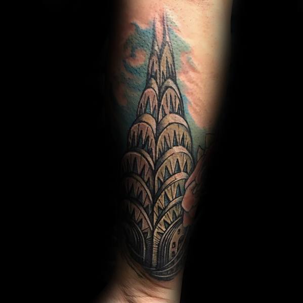 Colorful Chrysler Building tattoo with bold outlines, vibrant shading, and a soft sky backdrop, creating a striking architectural design.