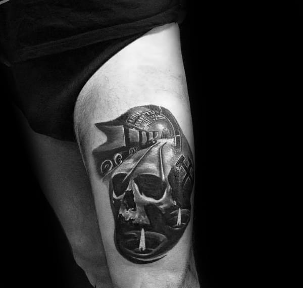 Black and grey thigh tattoo featuring a skull, mining helmet, and coal train with dramatic shadows and detailed realism.