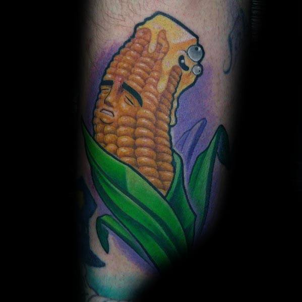Colorful tattoo of a corn cob with a melting butter face and expressive eyes, blending surreal and humorous elements in a bold design.