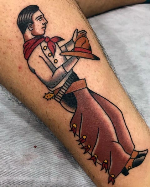 Tattoo of a traditional-style cowboy in chaps and a red neckerchief, holding his hat, done in bold colors with classic Western detailing.