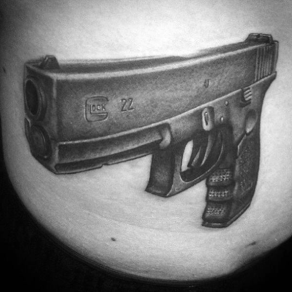 Black and grey tattoo of a distorted Glock 22 on the stomach, featuring exaggerated proportions for a surreal and bold artistic effect.