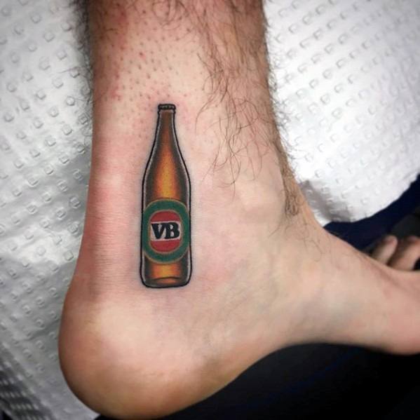 Small ankle tattoo of a Victoria Bitter beer bottle, featuring clean lines, subtle shading, and the signature green and red VB label.