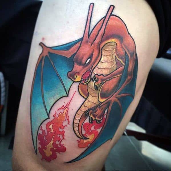 Fierce Charizard tattoo on thigh with vivid fire breath, bold outlines, and a vibrant teal and red color contrast.