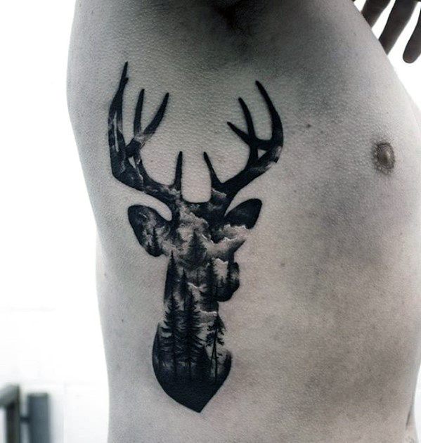 Blackwork tattoo of a deer silhouette filled with a misty forest and cloudy sky, blending wildlife and nature in a double exposure style.