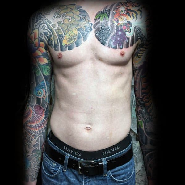 Japanese-style full chest and sleeve tattoos featuring turtles, waves, and floral elements in vibrant colors, creating a bold and dynamic design.